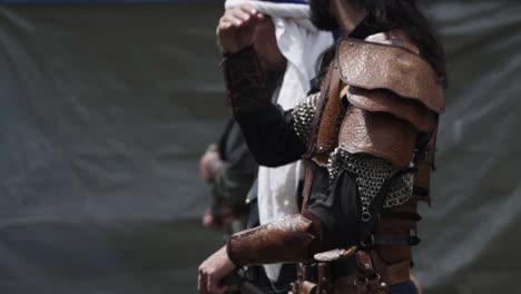close-up of medieval knight adjusting helmet during a reenactment, preparing for battle in the field
