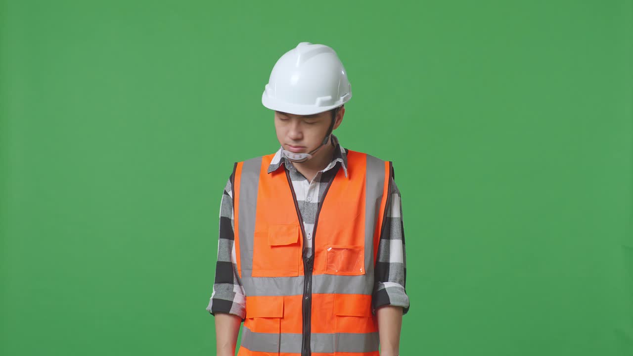 Asian Male Engineer With Safety Helmet Having A Headache While Working In The Green Screen Background Studio