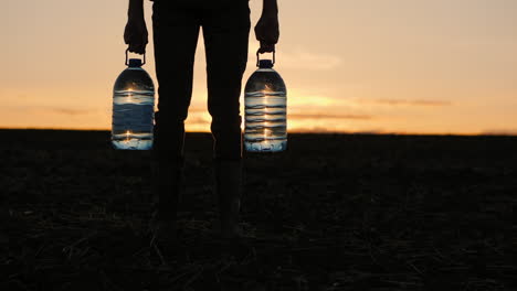 persona que lleva botellas de agua al atardecer