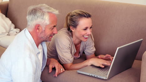 una pareja feliz usando una computadora portátil para comprar en línea