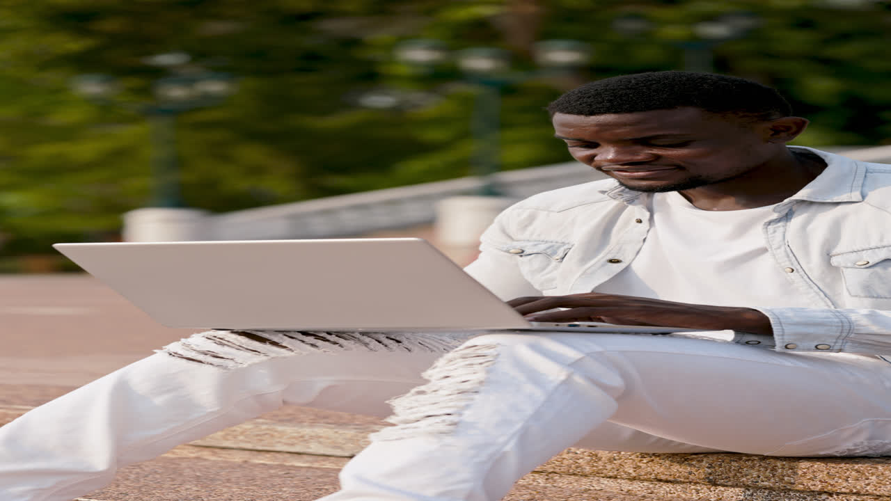 Young Man Working on Laptop Outdoors