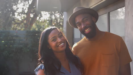 portrait of smiling african american couple talking and laughing in garden at home