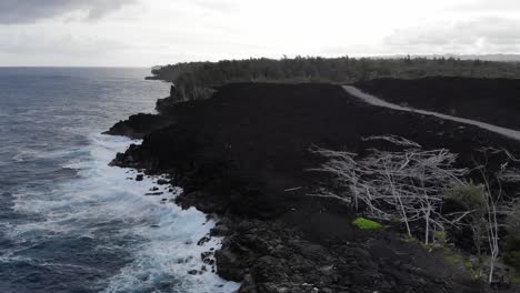 flying towards 2018 lava flow along coastline of hawaii puna with cars driving on top along a new road