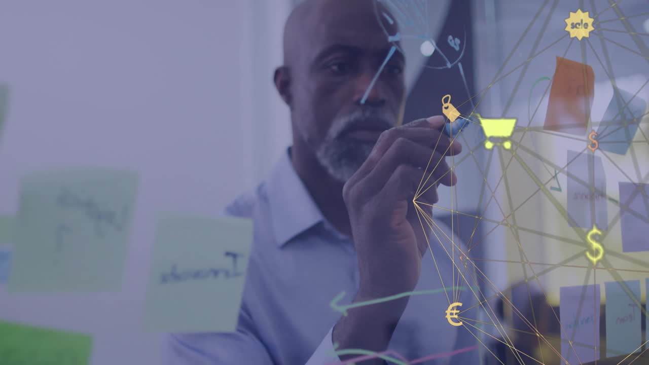 Animation of network of retail icons over african american casual businessman brainstorming at work
