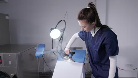 trabajadora planchando ropa en una lavandería