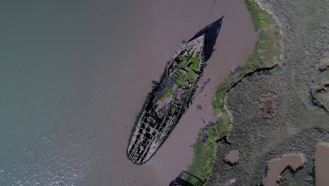drone ascendiendo sobre barco en ruinas en marismas en tollesbury marina, essex, reino unido
