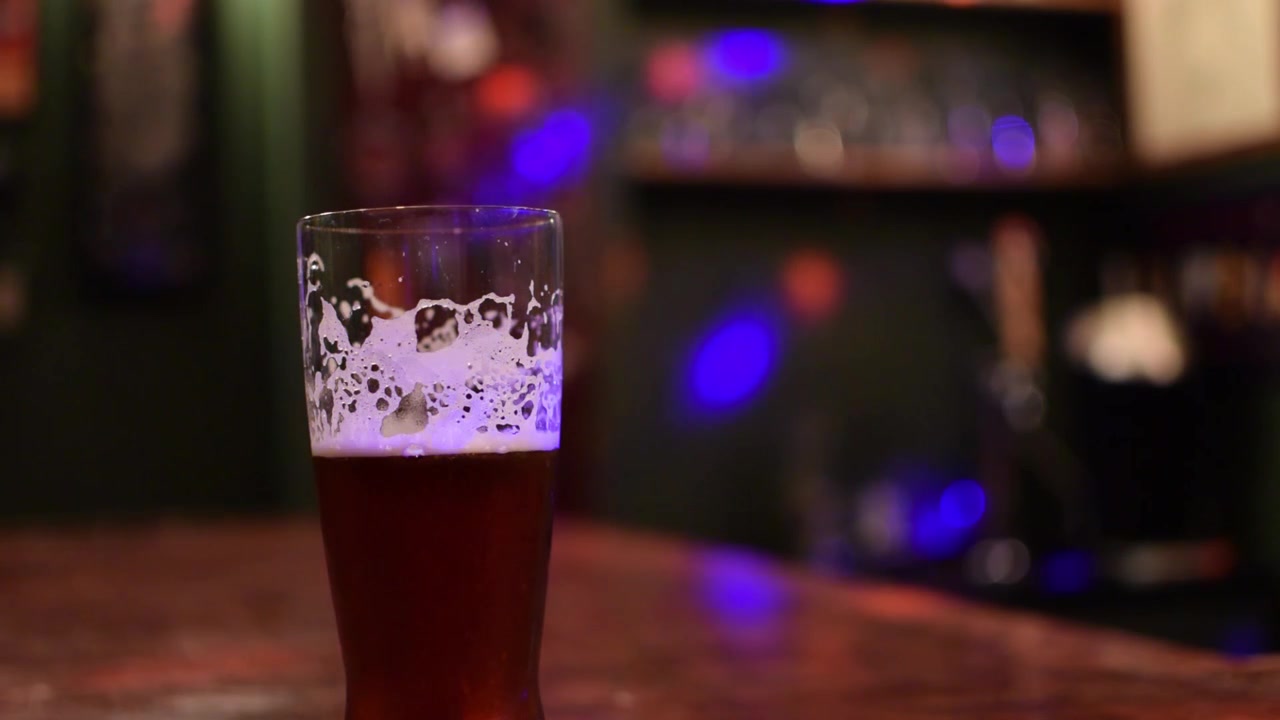 Øl på en bar med farvede discolys i baggrunden