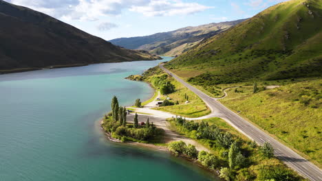 country asphalt road on lake of coastline of new zealand, aerial drone view