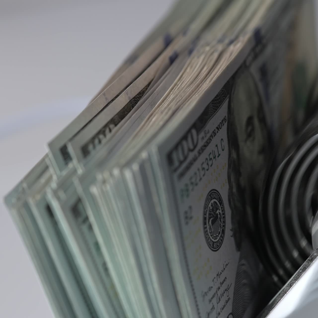 Mechanism in cash counting machine turning quickly. US hundred dollar banknotes counted in the money counting equipment. Close up