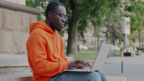 young man working on laptop on stairs