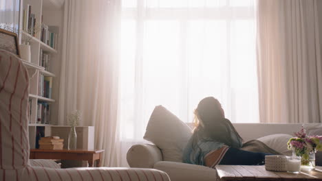 happy little girl jumping on sofa dancing having fun child in playful mood enjoying weekend morning at home with sunlight shining through window 4k footage