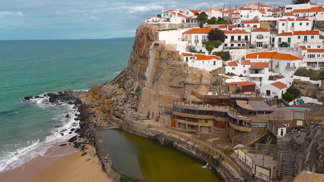 Las icónicas Azenhas do Mar situadas en dramáticos acantilados atlánticos con casas blancas, tejados rojos y una piscina natural junto al mar debajo