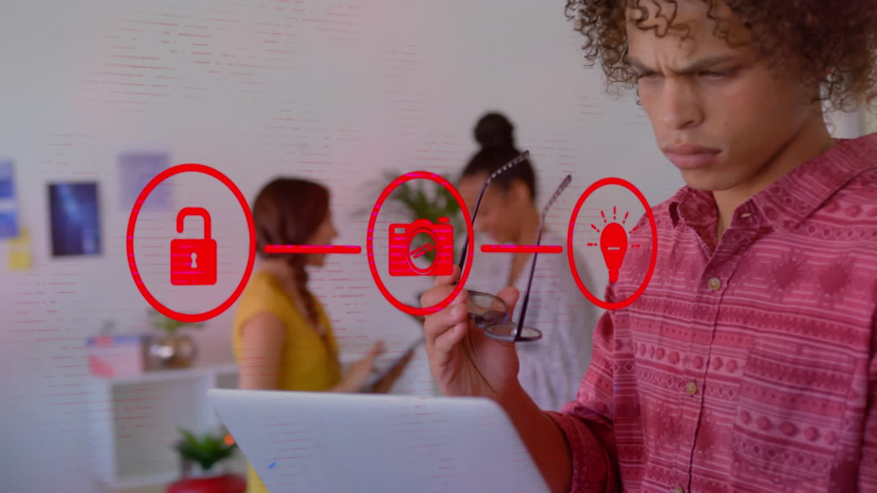 animación de tres iconos de medios rojos conectados sobre un hombre en una oficina casual usando una computadora portátil