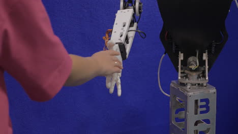 in moscow russia on exhibition robotix expo robot with arm shakes hands with girl