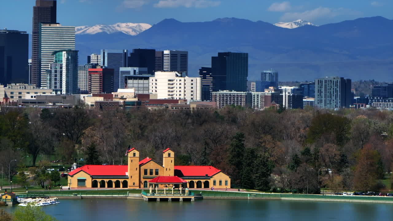 Downtown Denver City Park Pavillon building Colorado aerial drone springtime summer tree wildflower blossom sunny morning blue sky Ferril Duck Lake bike walking path tall skyscrapers pan left motion