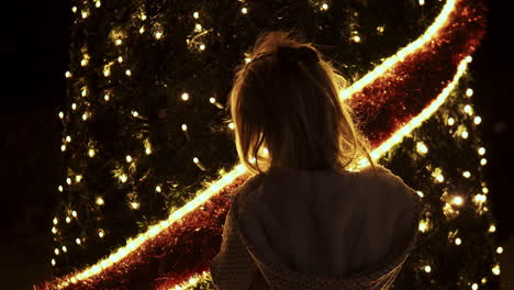 niña pequeña en el árbol de navidad