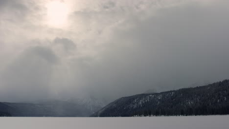Las-Nubes-Se-Mueven-Rápidamente-Sobre-El-Lago-Congelado-De-Gallineta-Nórdica-De-Idaho-En-El-Paisaje-Montañoso-Invernal