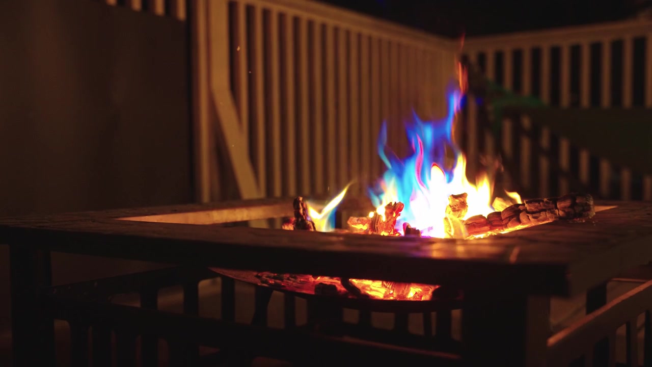 Fiamme e braci che bruciano dolcemente nella notte, falò nell'oscurità.