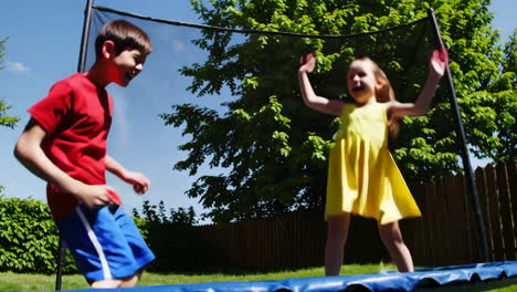 kids having fun jumping on a trampoline outdoors