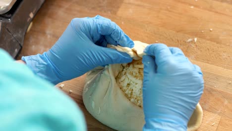 chef baker making pie from dough and cheese on wooden table before baking