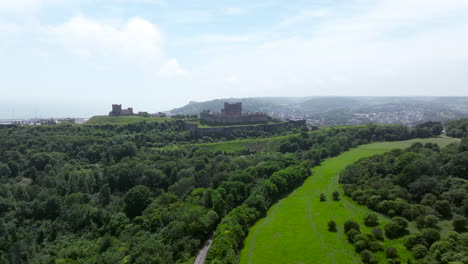 lush green forest and road near dover castle in dover, kent, england, uk. - aerialshot