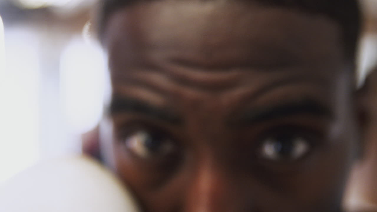 Close Up On Eyes And Face Of Male Boxer As He Trains In Gym