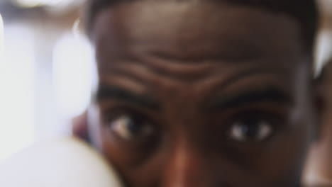 close up on eyes and face of male boxer as he trains in gym