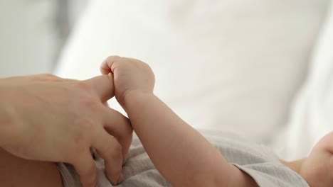 cerca del bebé sosteniendo la mano de la madre