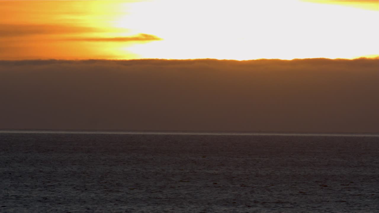 vista aérea hacia la playa de guincho, puesta de sol, en portugal - acercándose, disparo de drones