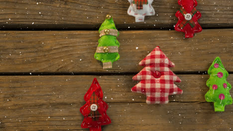 falling snow with christmas tree decorations on wood