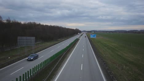 cars and trucks driving fast on the road of zlotoryja in poland at dusk - ascending drone shot