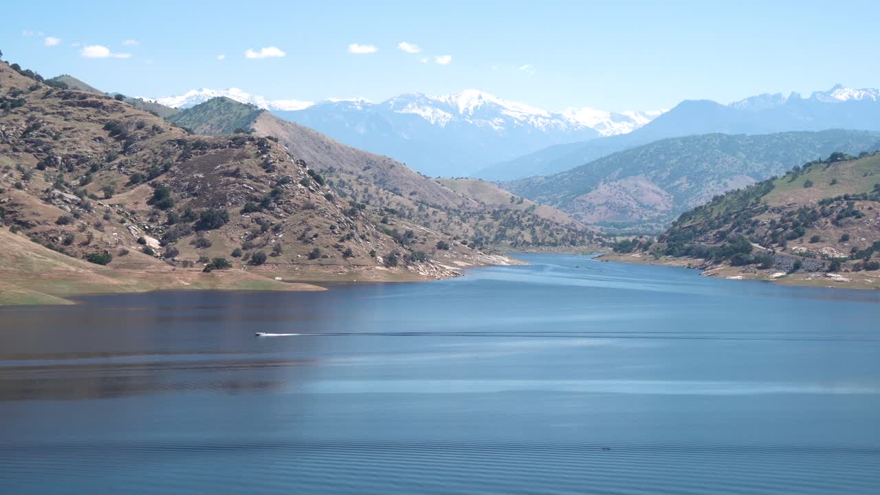 눈 덮인 봉우리와 모터보트 전진, 와이드 핸드헬드 샷이 있는 캘리포니아의 타호 호수