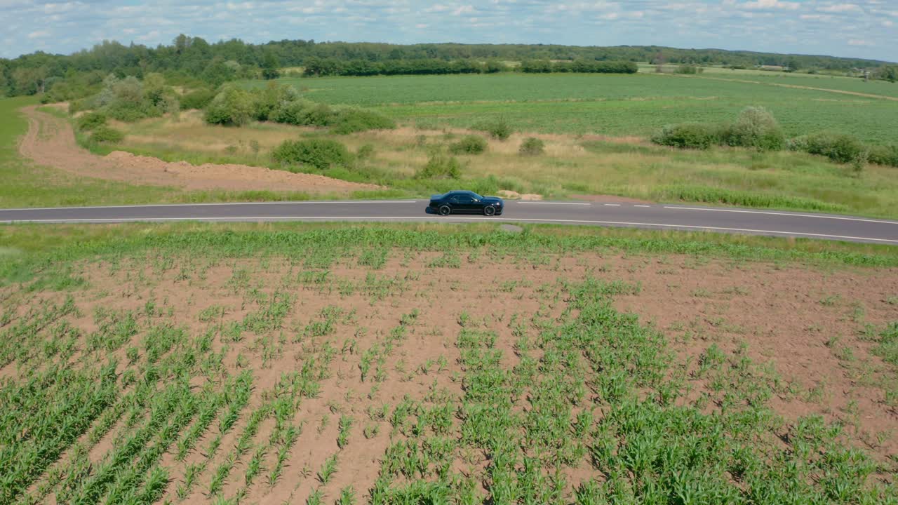 Sweeping drone orbit around a classic American muscle car A Black Dodge Chellenger 6.4l Scat Pack
