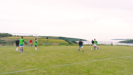 Male and female soccer players, and shooting at goal on pitch, slow motion, copy space