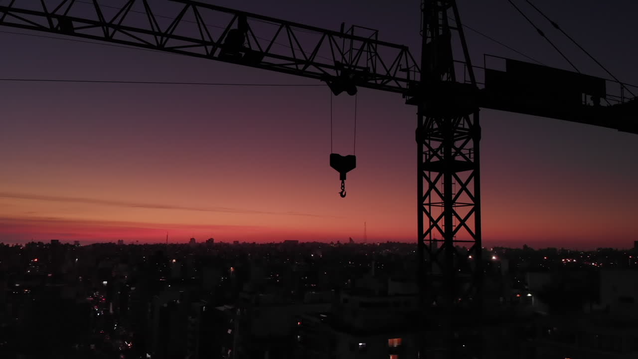 grúa de construcción en la ciudad en la órbita del atardecer medio disparo