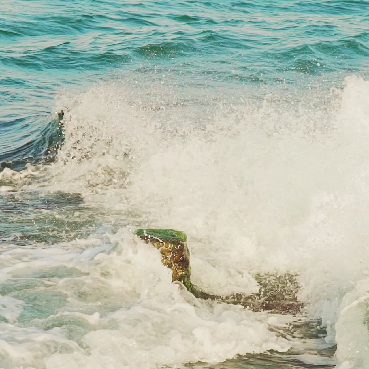 Breakwater and splashes of wave in sea shore. Slow motion