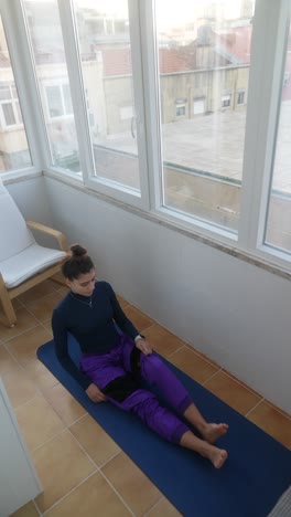 woman doing yoga stretches on a balcony