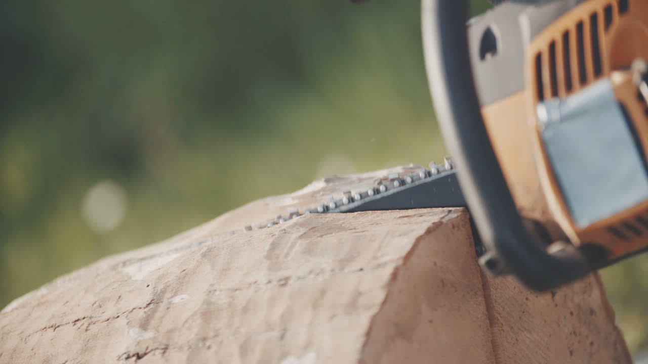 человек пилит дерево бензопилой