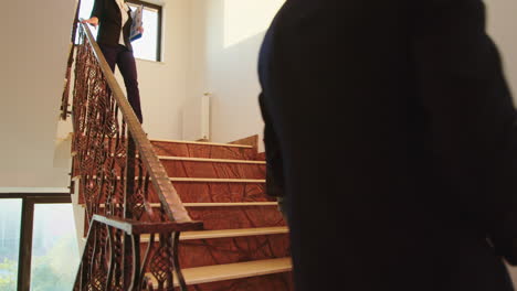 Business-colleagues-standing-and-smiling-on-office-stairs