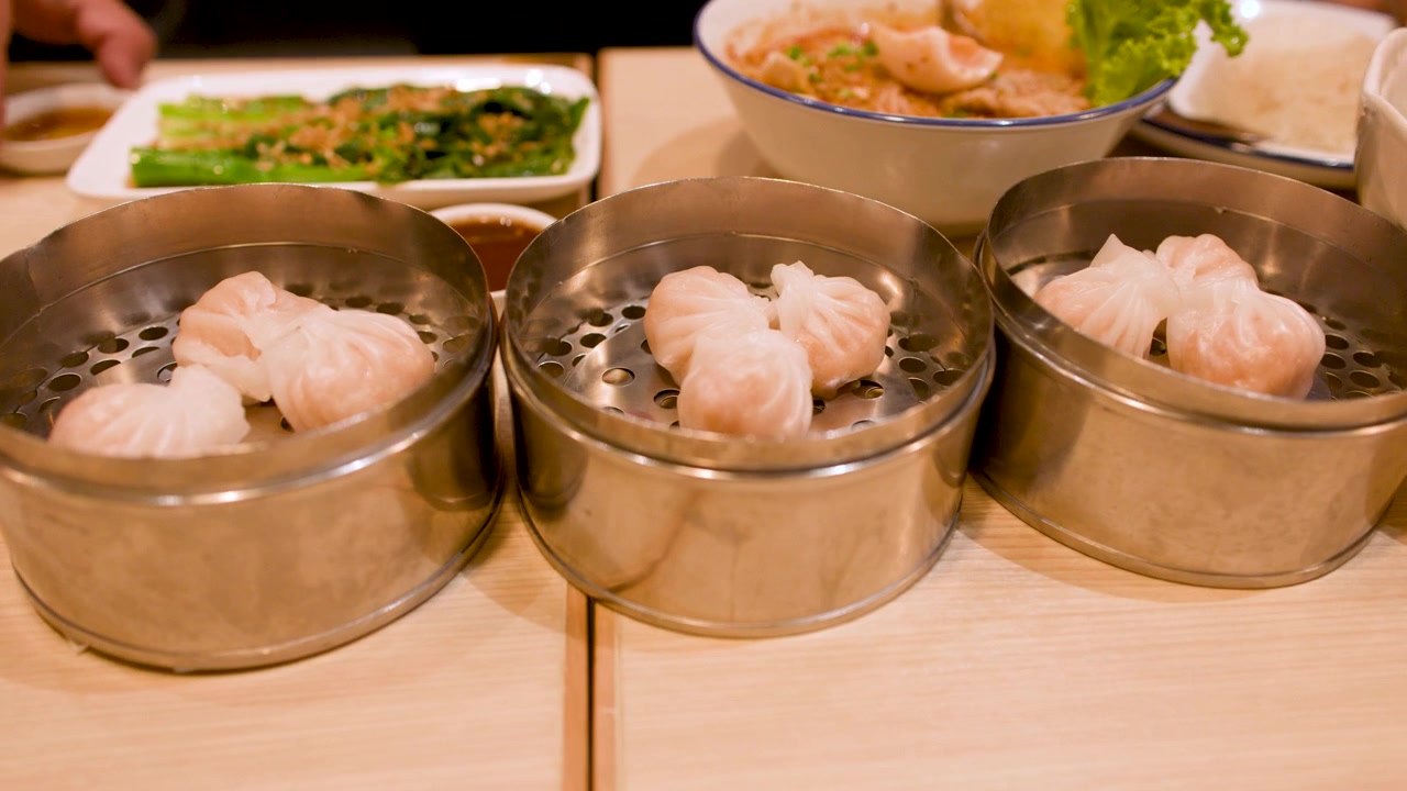 Close-up of dim sum shrimp dumplings in metal baskets at a restaurant in Bangkok, Thailand.