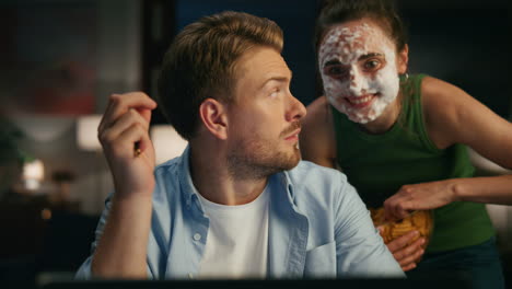 domestic woman frighting husband home closeup. girl in face mask waving laptop