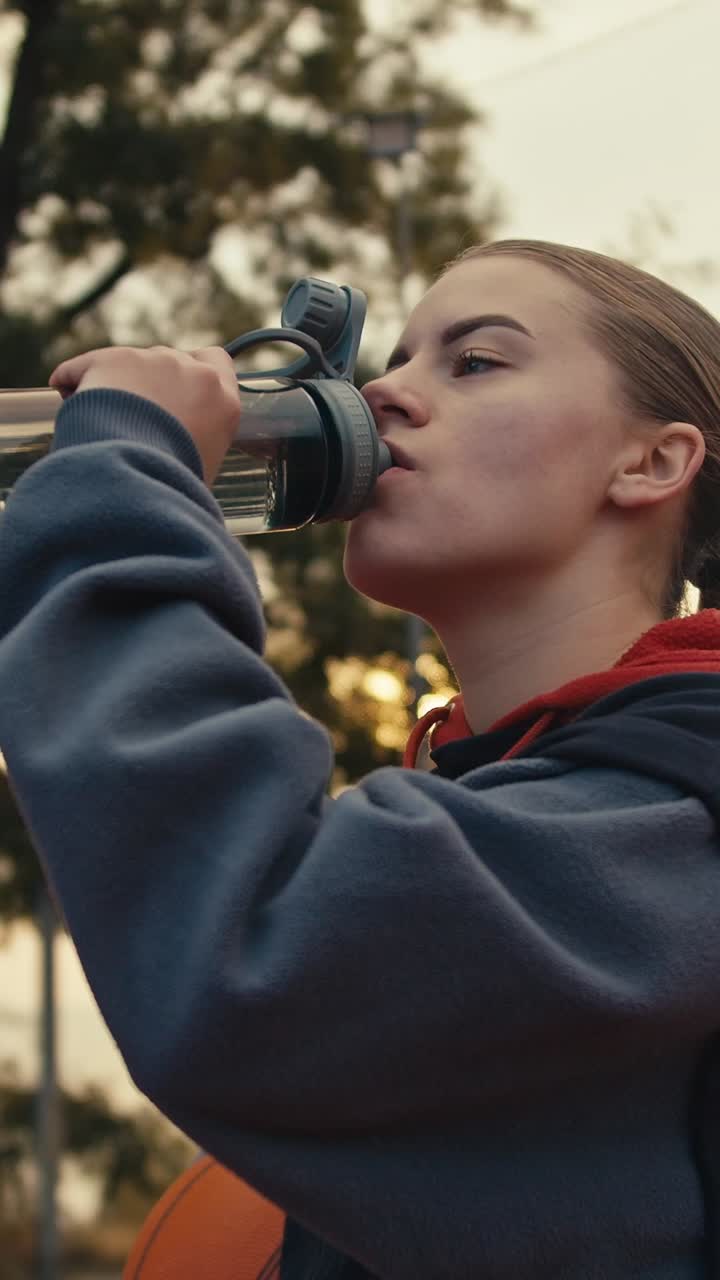 Woman Drinking Water After Basketball Practice