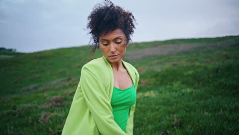expressive woman dancer performing modern dance at green cloudy field close up.