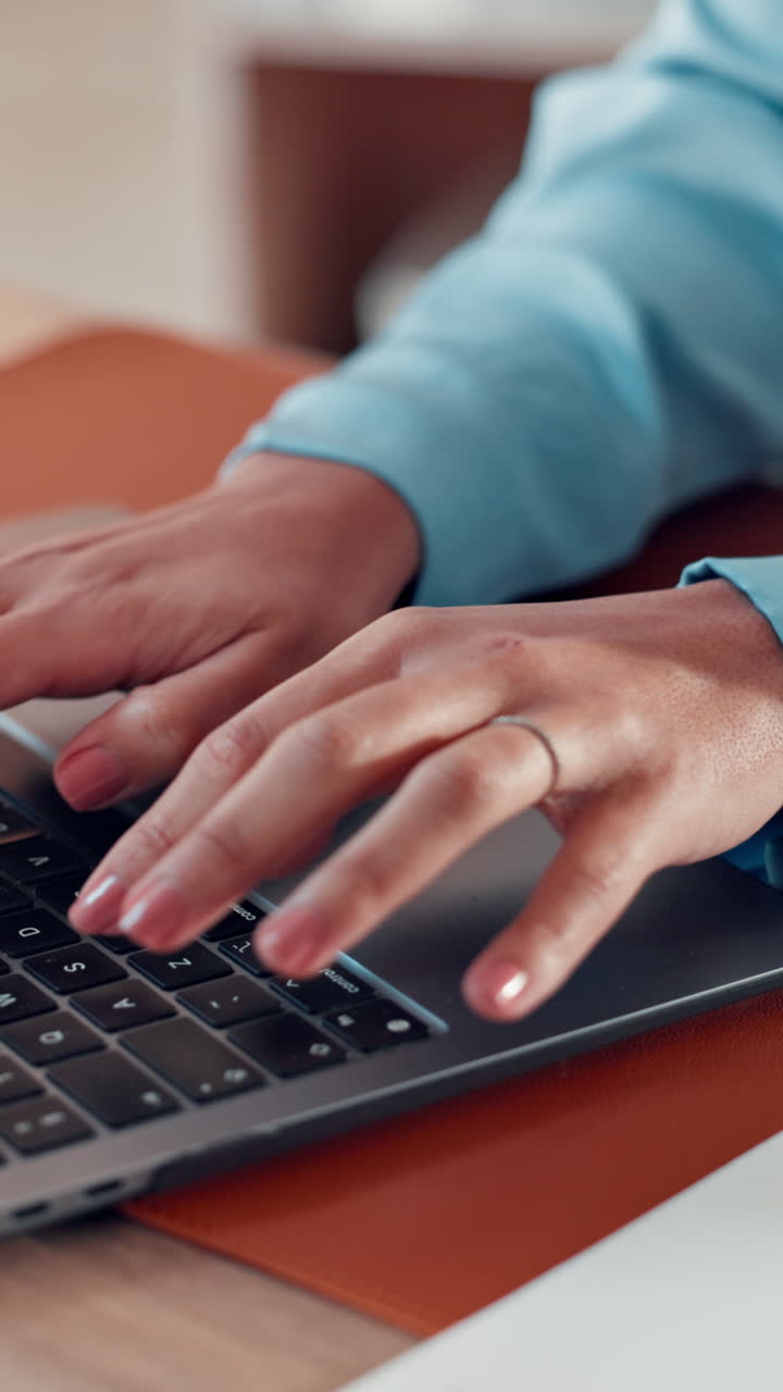 Person's Hands Typing on a Laptop Keyboard at a Desk