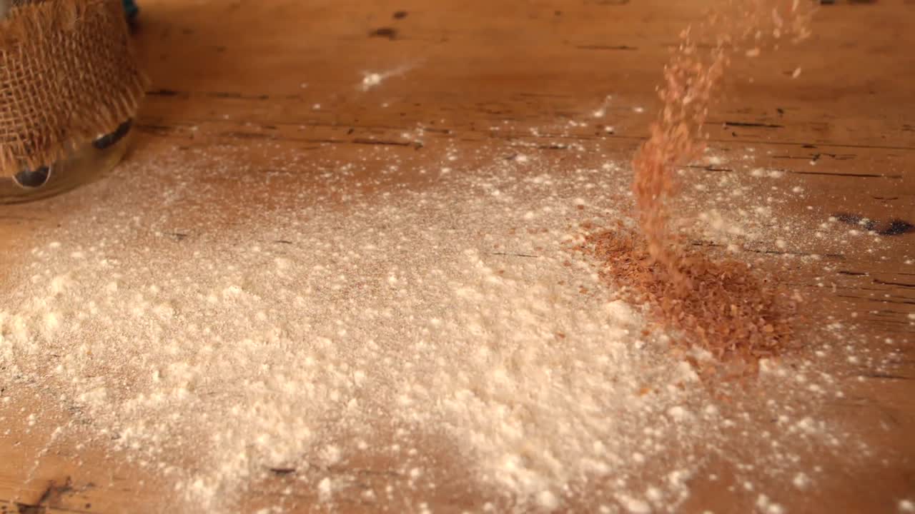 Flour and bran sprinkled onto wooden work surface