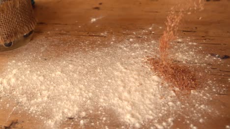 Flour-and-bran-sprinkled-onto-wooden-work-surface