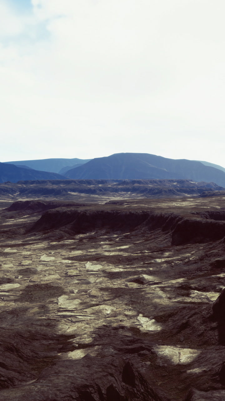 Vast and rugged terrain stretches endlessly under a bright sky