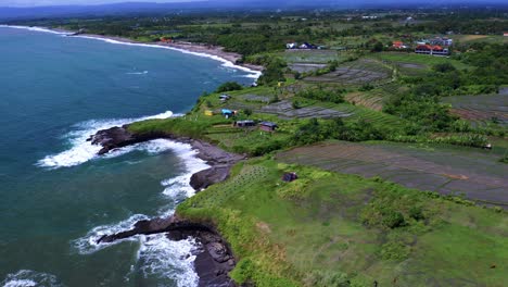 waves breaking against the rocky shoreline of beach in summer in bali, indonesia