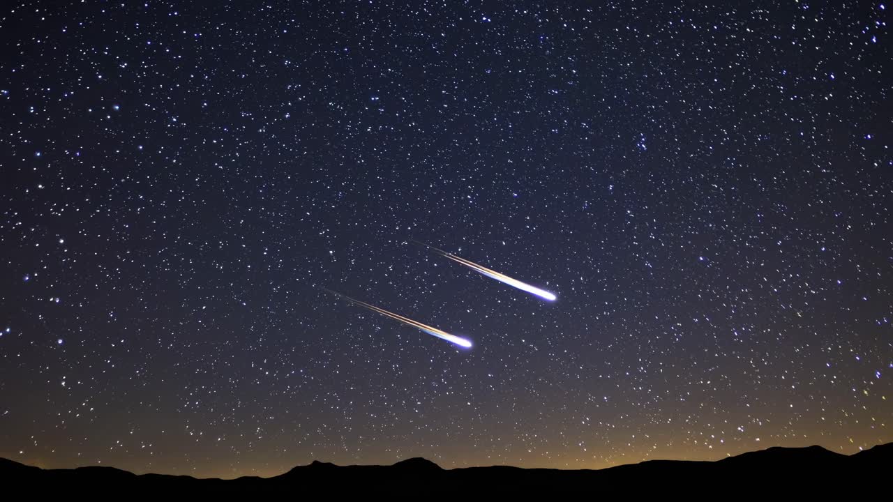 A wide-angle video captures a starry night sky with two bright meteors streaking