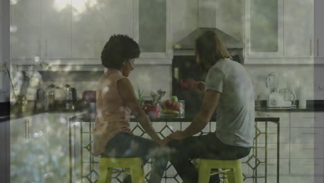 at kitchen counter, couple having drinks and conversation, smiling and relaxed